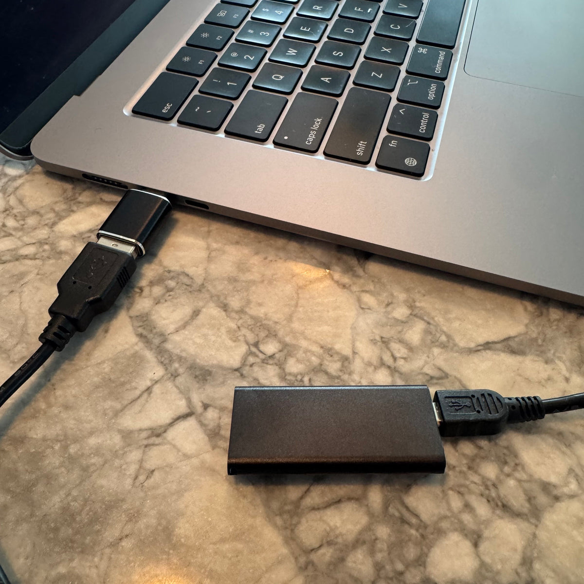 Micro voice recorder connected to a Mac laptop by USB
